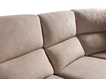 A detailed view of the Atlas Recliner Köşe Takımı, a contemporary L-shaped corner sectional sofa upholstered in textured beige fabric. The image shows its modern design with sleek lines and wide seats. The central console unit is featured, with an open lid, integrated cup holders, and a built-in Bluetooth speaker system visible on the side. The sofa is placed in a premium living room with light wood floors and textured wall paneling with LED backlighting.