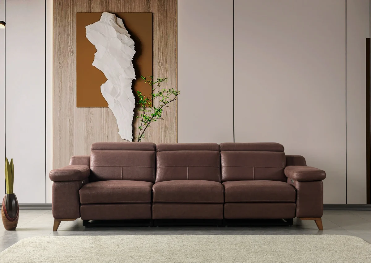 A detailed view of the Serena Motorized Triple Recliner, a premium brown three-seater sofa manufactured by Chairium, featuring extended motorized footrests and adjustable headrests on the outer seats.