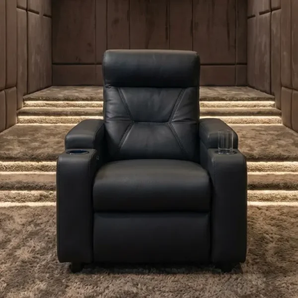 A front-facing view of the Zero Plus recliner, featuring a plush black leather design with geometric backrest stitching and built-in armrest cup holders, positioned in a sophisticated home cinema setting with illuminated, carpeted steps.