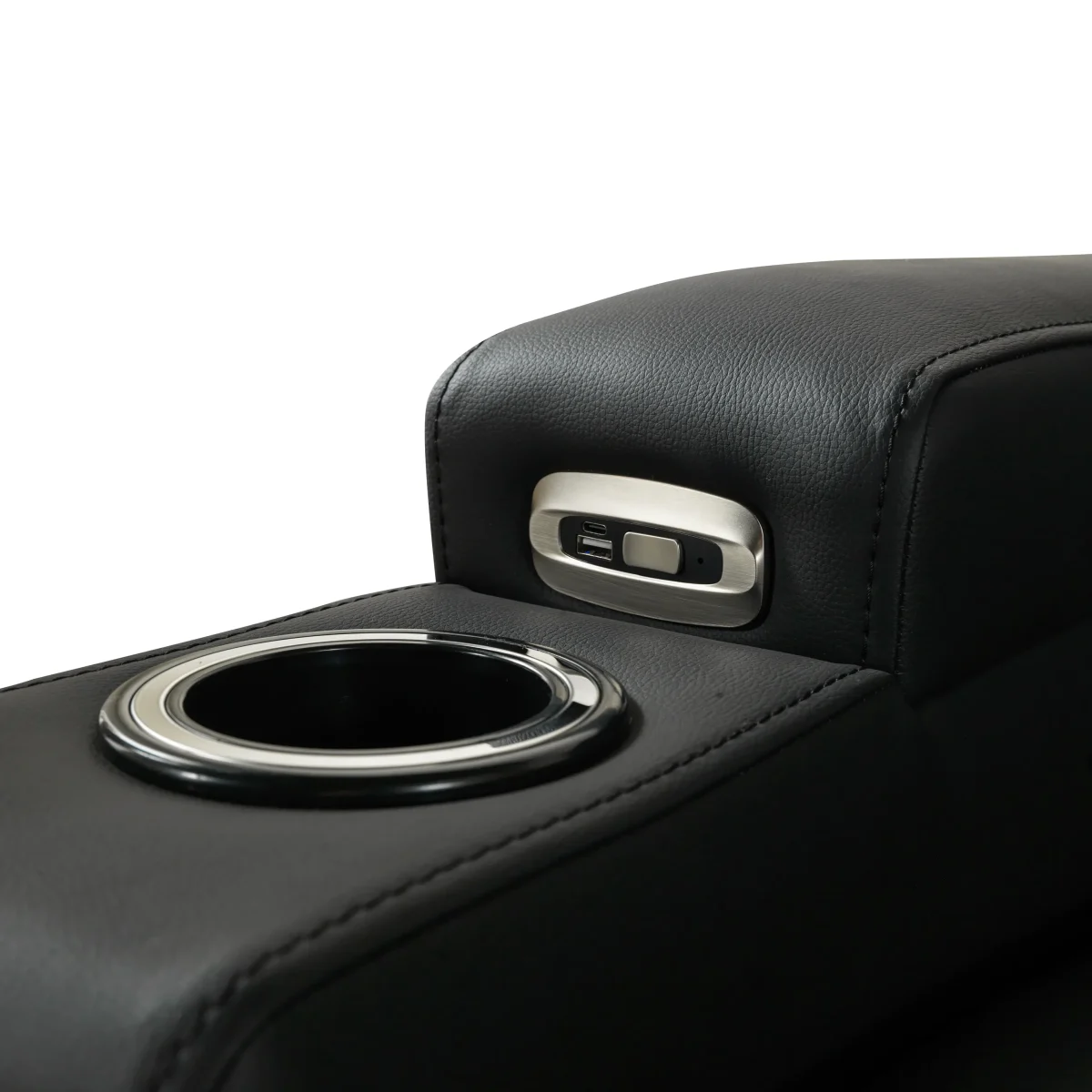 A front-facing view of the ZERO PLUS recliner, a luxurious black leather recliner chair with ergonomic stitched paneling and built-in cup holders. The recliner is centered on a light rug in a modern living room setting featuring elegant wood wall panels, accompanied by a tall woven vase holding decorative dry grass.