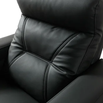 A front-facing view of the ZERO PLUS recliner, a luxurious black leather recliner chair with ergonomic stitched paneling and built-in cup holders. The recliner is centered on a light rug in a modern living room setting featuring elegant wood wall panels, accompanied by a tall woven vase holding decorative dry grass.